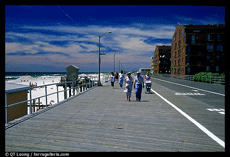 People walking on a wide wooden boardwalk.