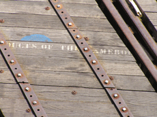 Close-up of a few railroad ties, one of which has white lettering on it