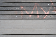 Close-up of tan-colored decking boards, with wood above and plastic below � they look nearly the same.