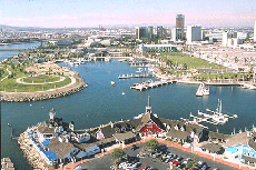 Aerial view of a harbor with piers. waterfront buildings and a few boat slips off to the right.