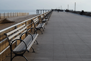 Boardwalk decking and benches with people in the distance